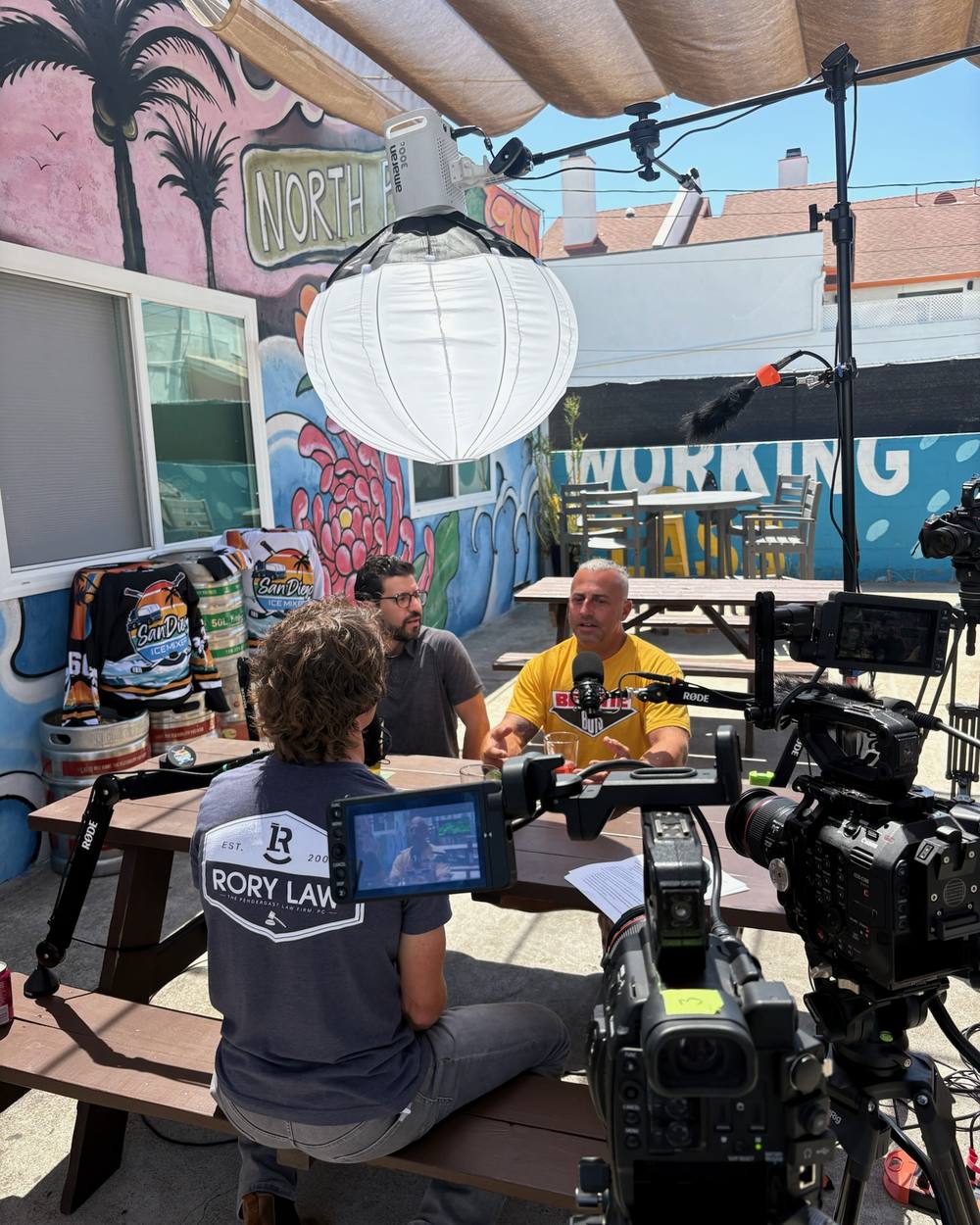 Outdoor podcast recording in front of a mural in North Park